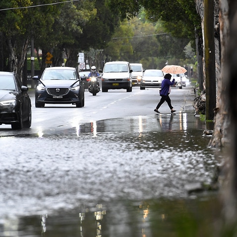 Cars navigate through minor flood waters as rain continues to fall across much of New South Wales causing localised flash flooding in Sydney, Friday, November, 26, 2021. (AAP Image/Dean Lewins) NO ARCHIVING