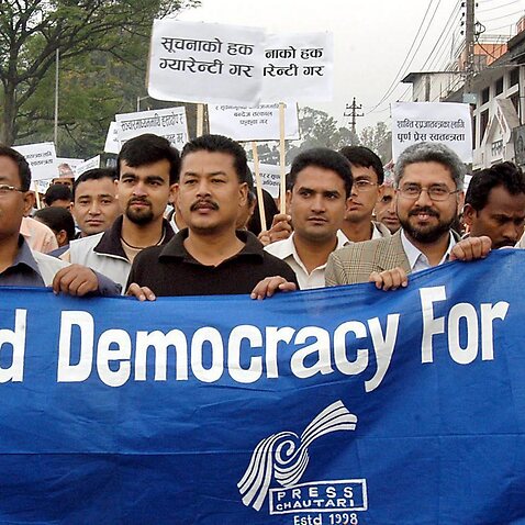 epa000425420 Nepalese journalists hold a banner during a world press freedom day rally in Kathmandu on Tuesday