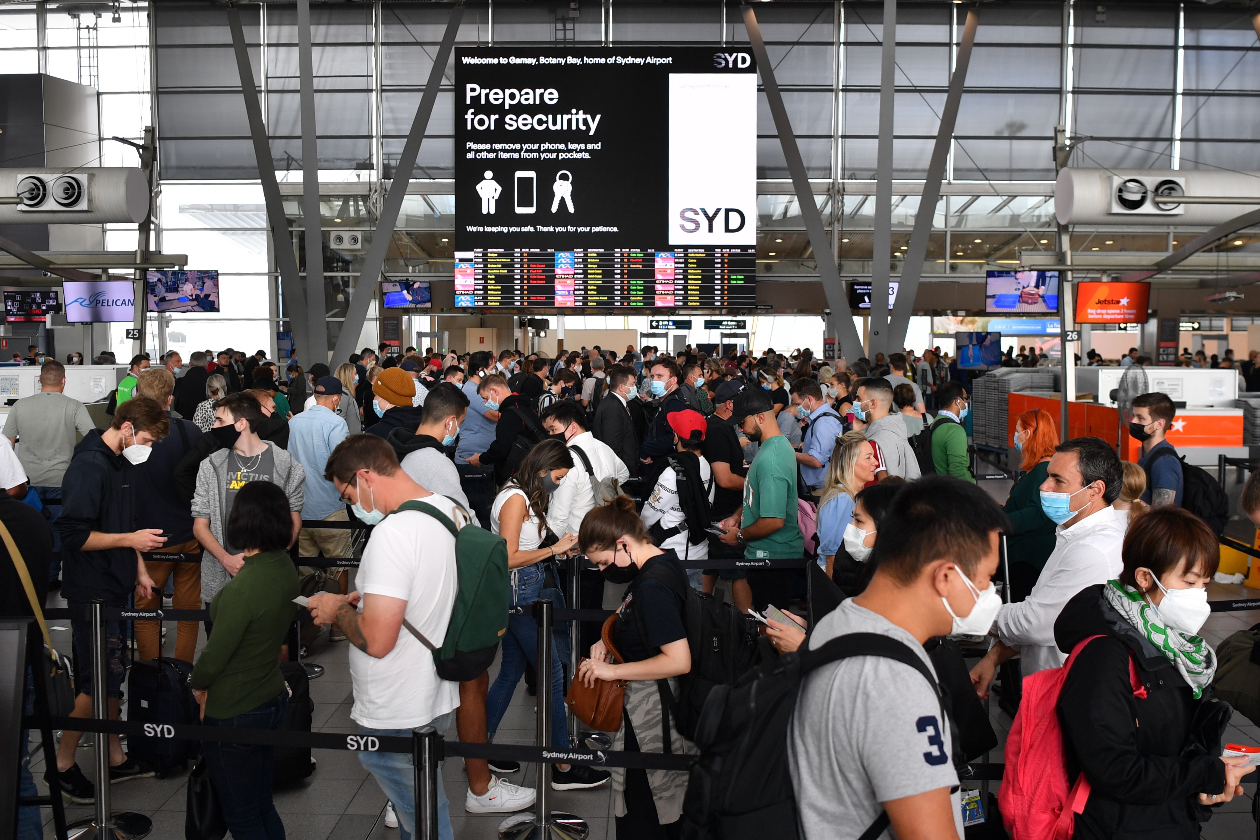 Huge queues are seen at the Virgin and Jetstar domestic departure terminal at Sydney Domestic Airport in Sydney, Friday, April 8, 2022. Domestic airline travels are queued outside the airport, forced to wait hours to get through check in and security. (AA