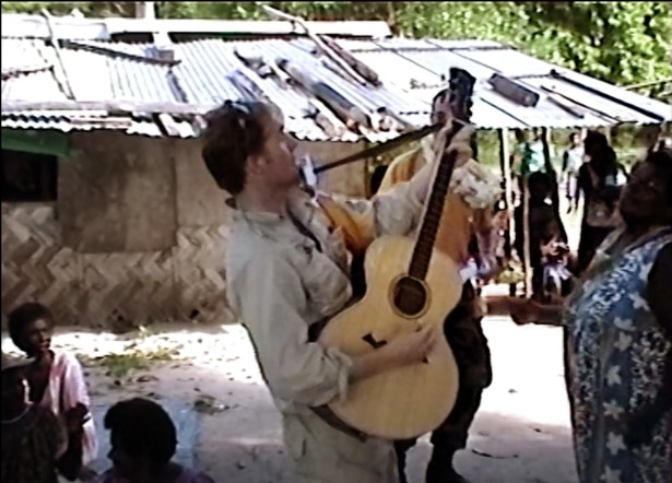An ANZAC peacekeeper plays his guitar to Bougainvilleans.