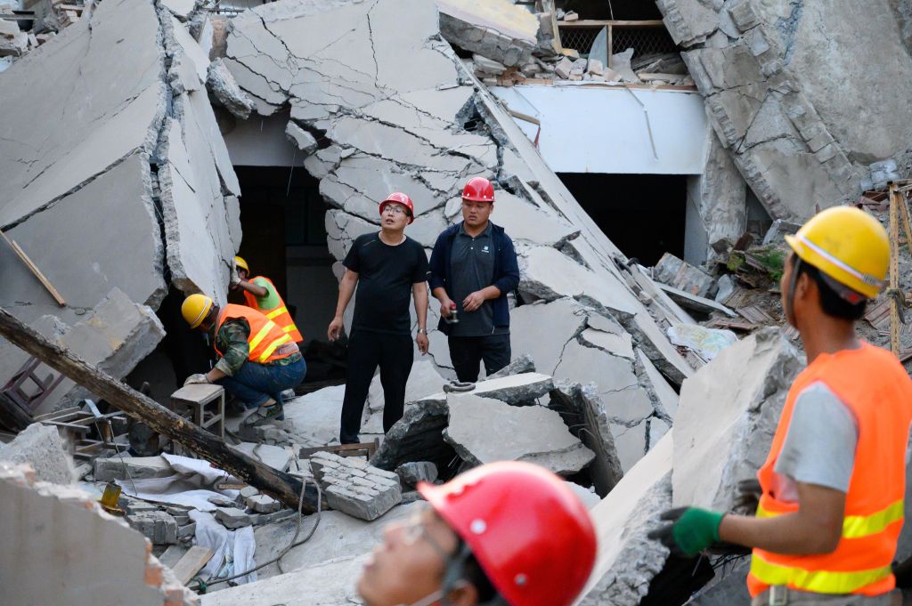Rescue workers search for survivors in the debris following the building collapse at Chenzhuang village. 