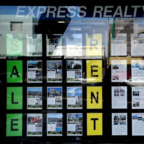 Houses for sale and lease advertised in the window of a real estate agent