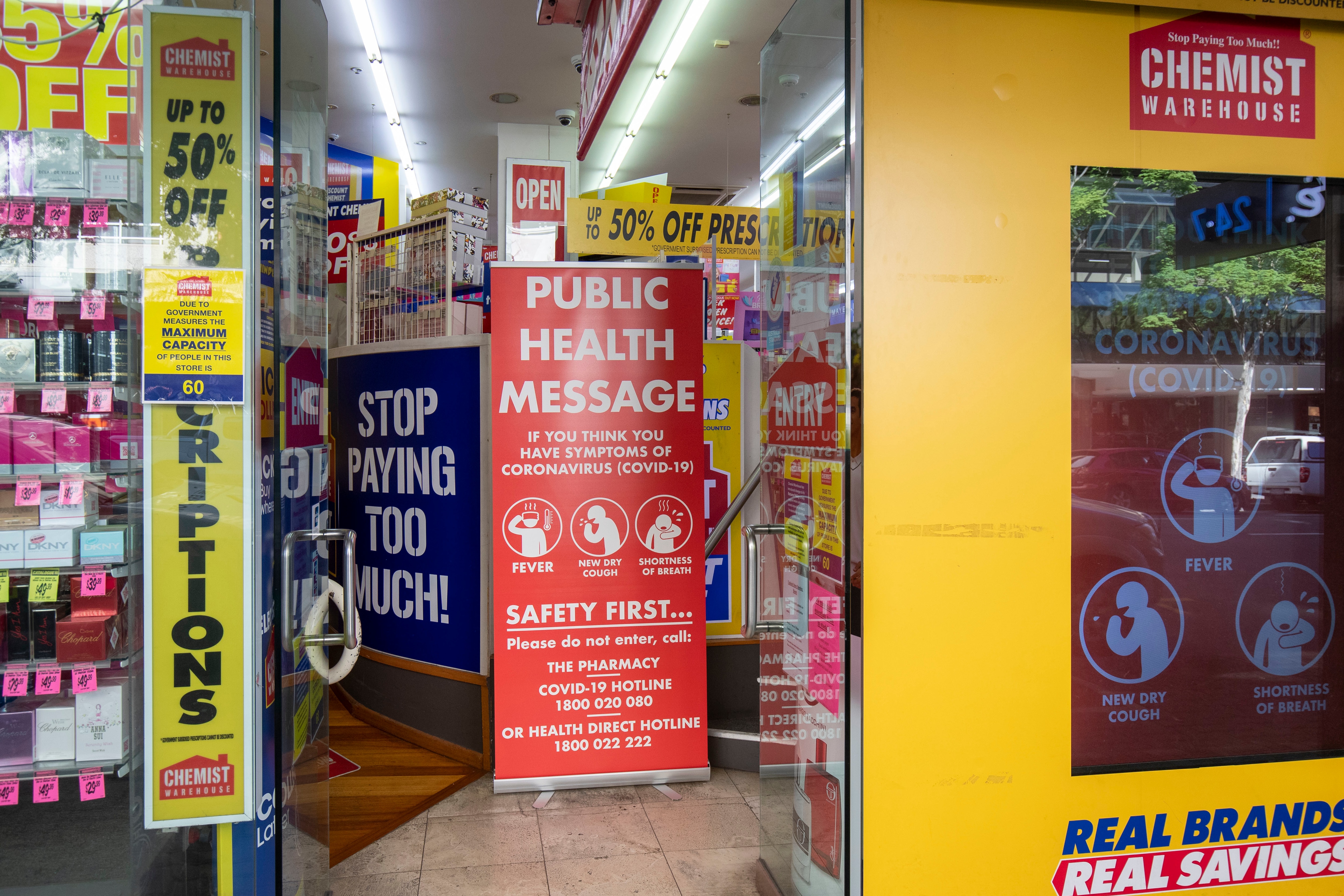 A Covid-19 public health message is seen at the entrance of a Chemist Warehouse in Brisbane, Friday, May 1, 2020. (AAP Image/Glenn Hunt) NO ARCHIVING