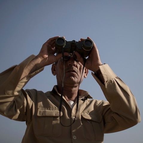 A Kurdish Peshmerga fighter looks at Islamic State positions during heavy fighting in Bashiqa, east of Mosul, Iraq, Tuesday, Nov. 8, 2016. 