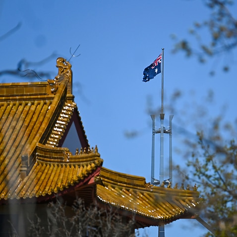 The flag pole of the Australian Parliament is seen behind the roof of the Chinese Embassy in Canberra.