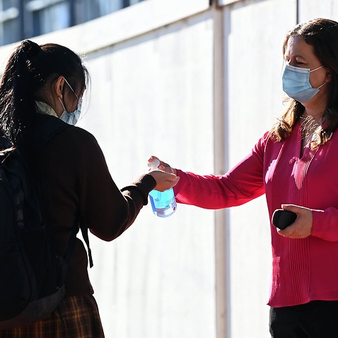 A student applies hand sanitiser in NSW 