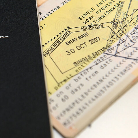 An Australian passport is pictured next to an entry visa to Papua New Guinea in Brisbane.