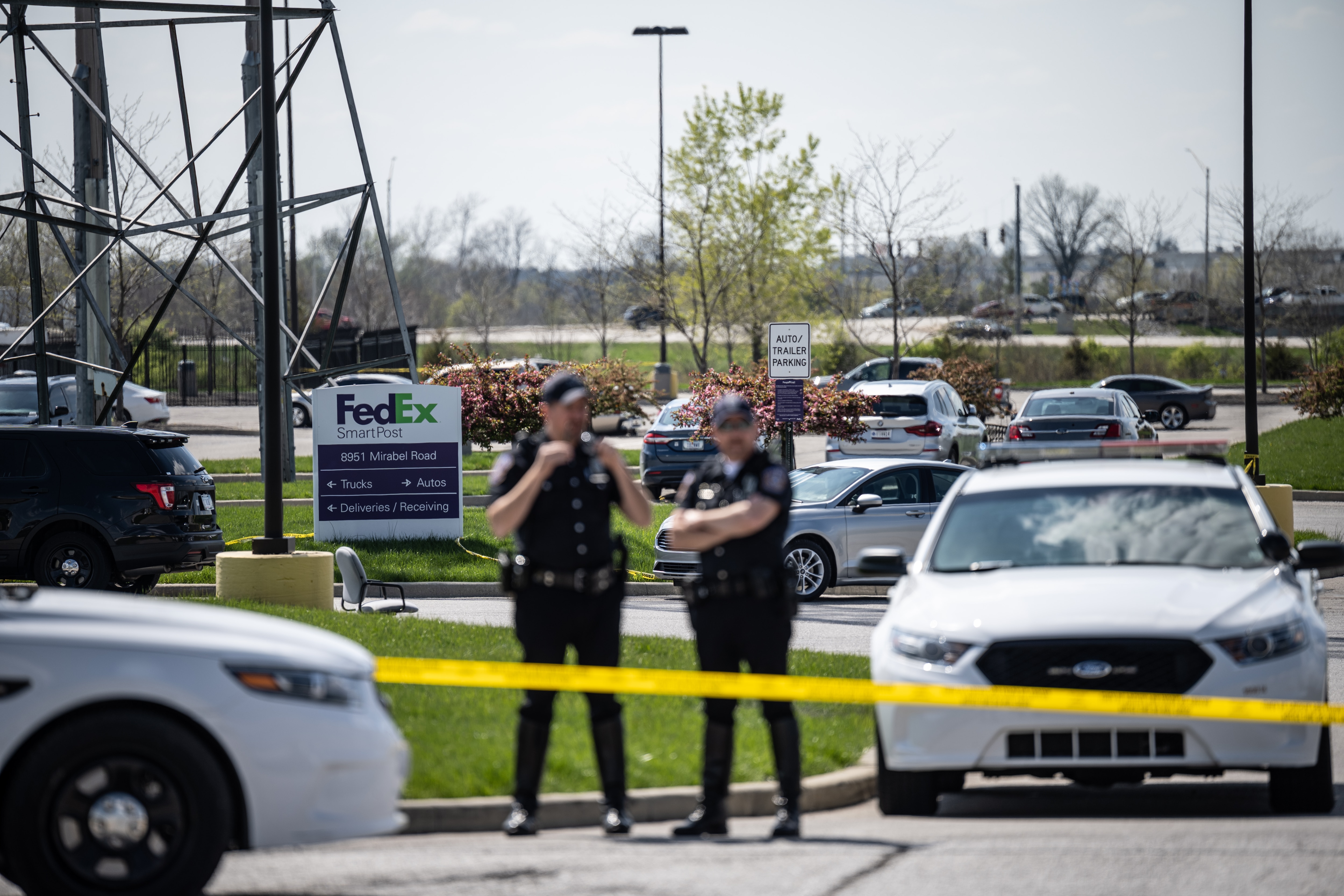 Police officers stand behind caution tape near the scene of the Indianapolis shooting on 16 April, 2021.