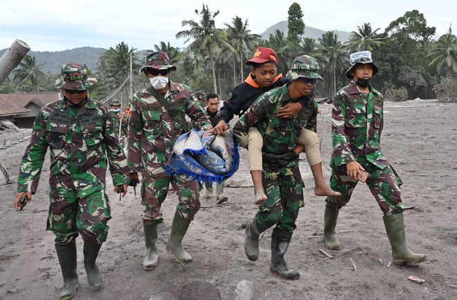 Rescuers carry a victim in Sumurwuluh.
