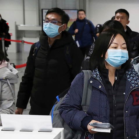 Correction: Passengers wearing mask walk at quarantine inspection during the time when a flight arrived from Wuhan at Kansai International Airport in Osaka.