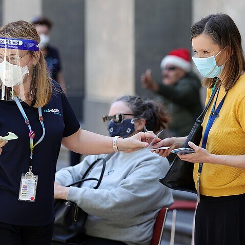 People are seen at a Cohealth pop-up vaccination clinic at the State Library Victoria, in Melbourne, Monday, December 20, 2021