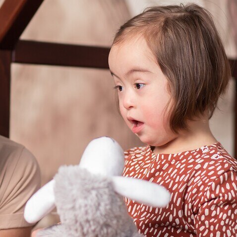 International Down Syndrome Day, March 21,cute baby girl with mom playing with toys - stock photo