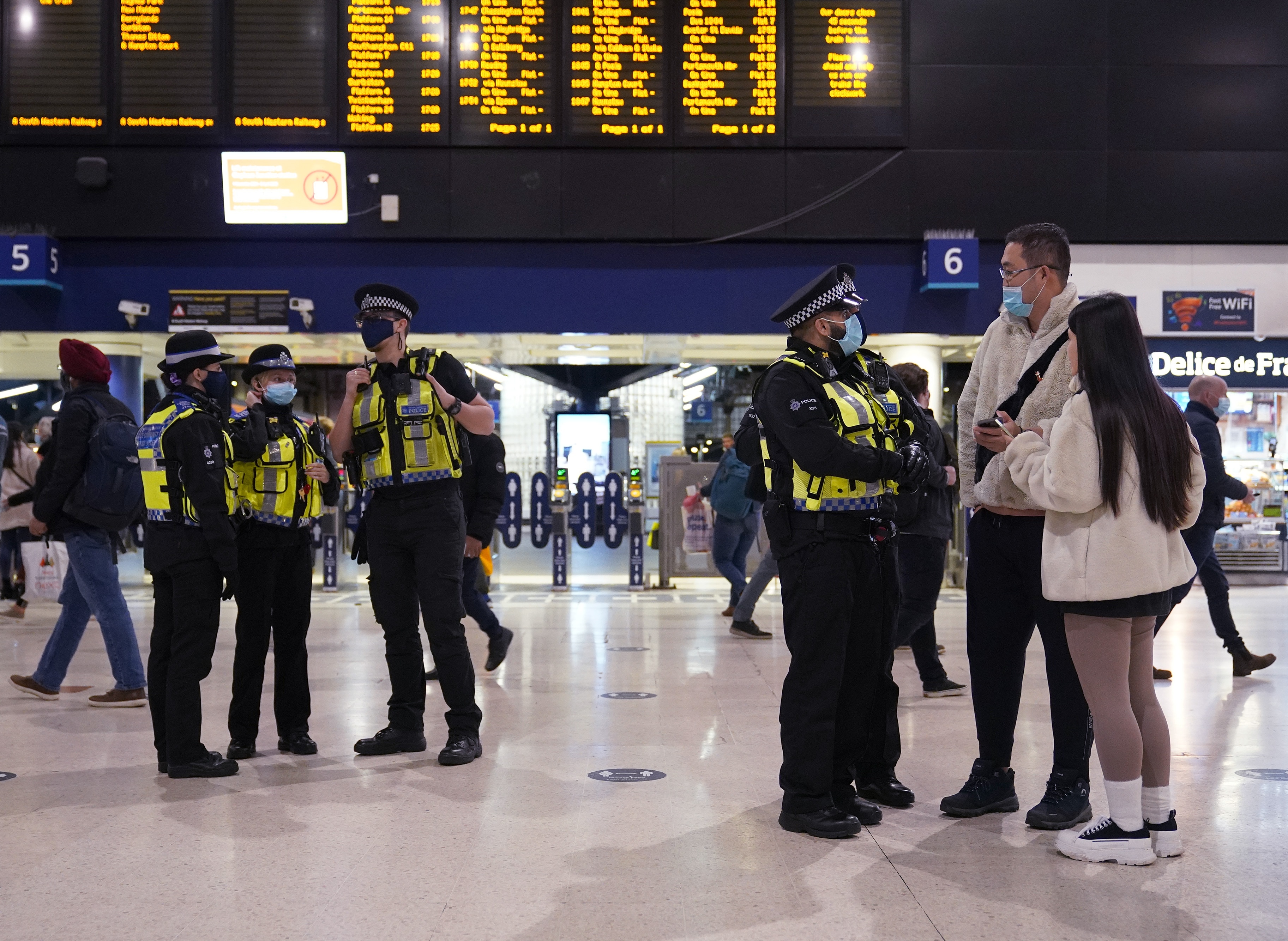 Police on patrol at Waterloo Station, London, in the evening rush hour, where new restrictions have come into force to slow the 