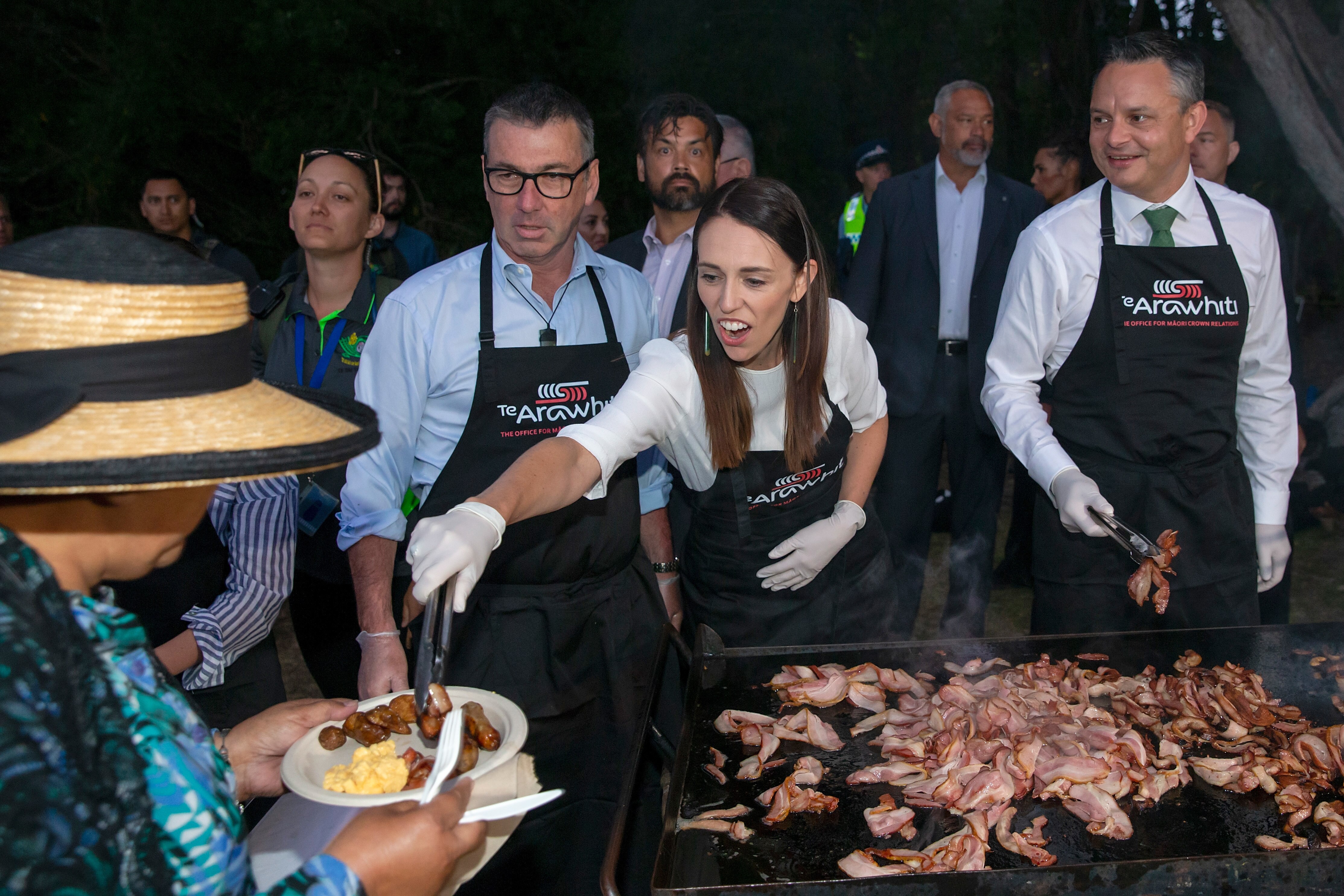 NZ Labour MP Duncan Webb, PM Jacinda Ardern and Climate Change Minister James Shaw serve up a barbecue after a dawn ceremony on Waitangi Day in 2020.