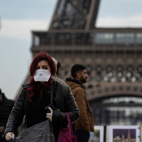 A woman wears a protective face mask near the Eiffel Tower, in Paris, France.