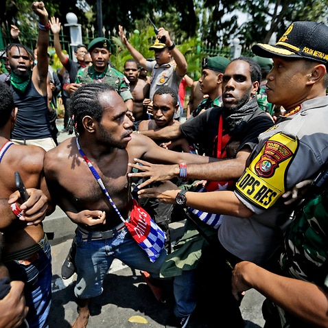 Papuan activists scuffle with police and soldiers during a rally near the presidential palace in Jakarta, Indonesia. 