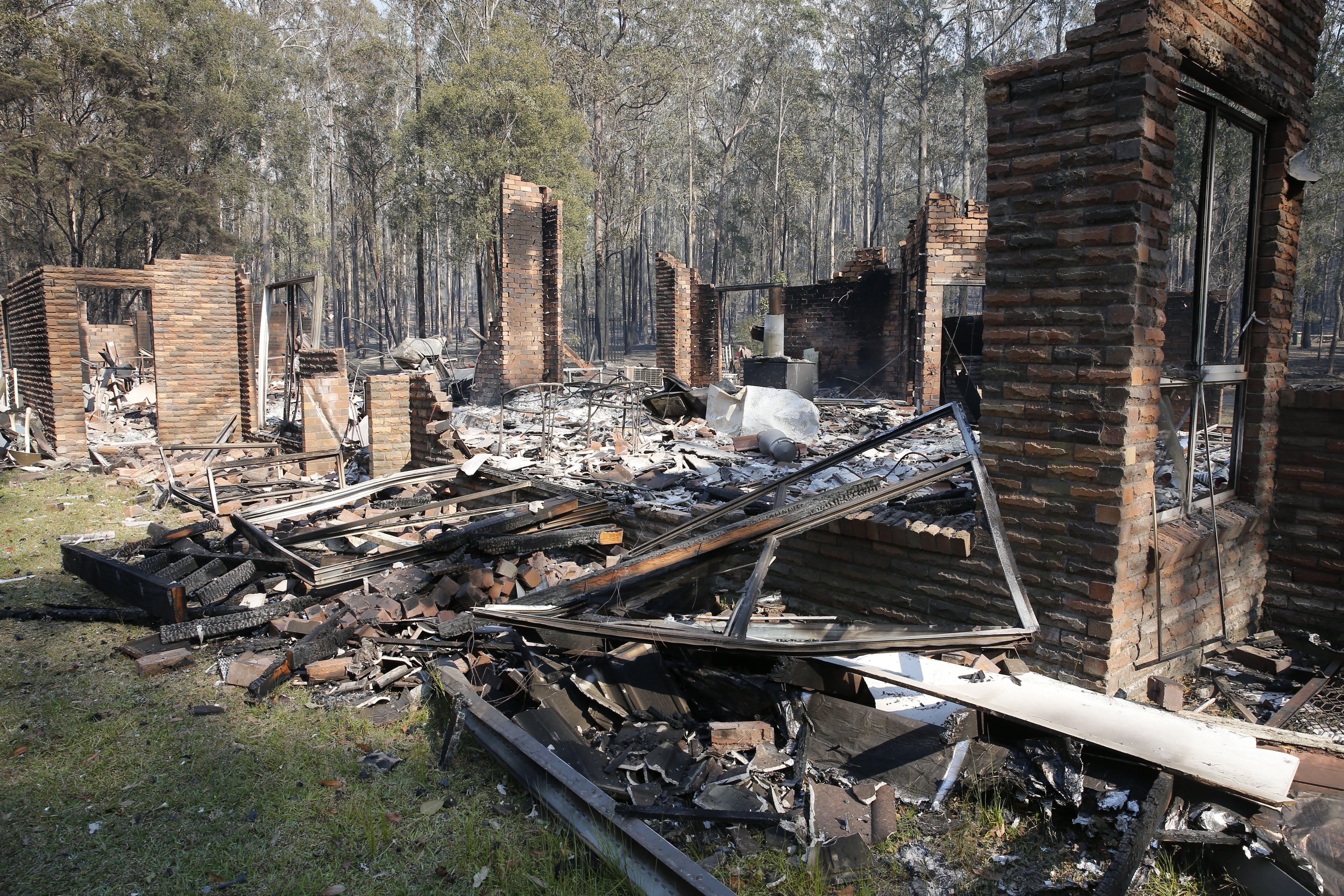 The remains of the residence at Four Paws boarding kennels smoulders along the Pacific Highway south of  Taree, Saturday, November 9, 2019.  (AAP Image/Darren Pateman) NO ARCHIVING, EDITORIAL USE ONLY