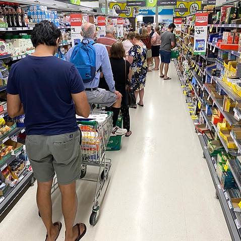 People are seen lined up waiting to go through the checkout inside Woolworths at Mt Gravatt in Brisbane on 8 January ahead of a three-day lockdown. 