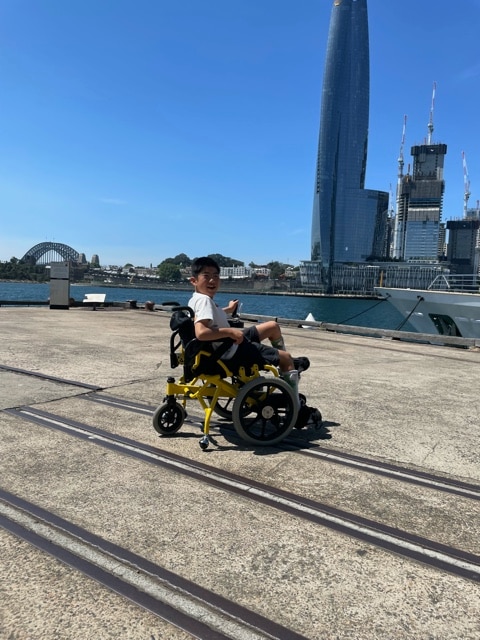 Kanga Tanaka is in a Cogy pedal wheelchair in Sydney.  Cogy wheelchair was developed in Japan, and it become commercially available for children in 2019.