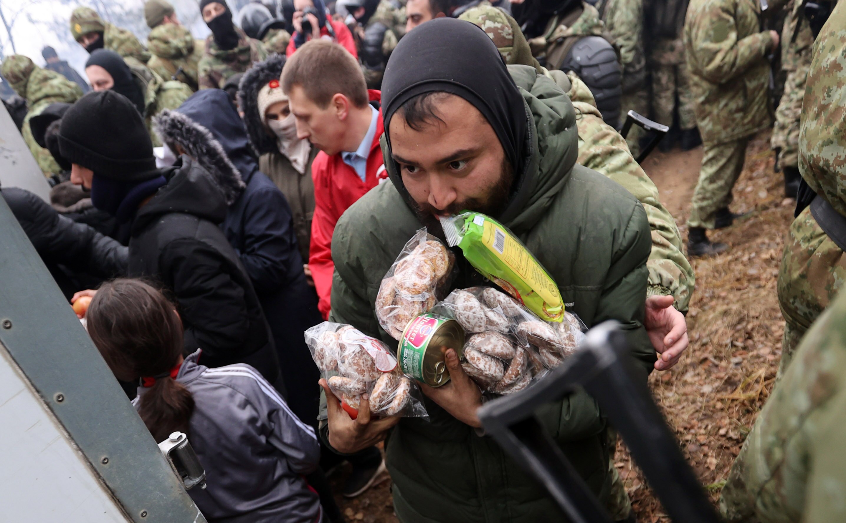 Migrants receive food supplies in a tent camp on the Belarusian-Polish border. 
