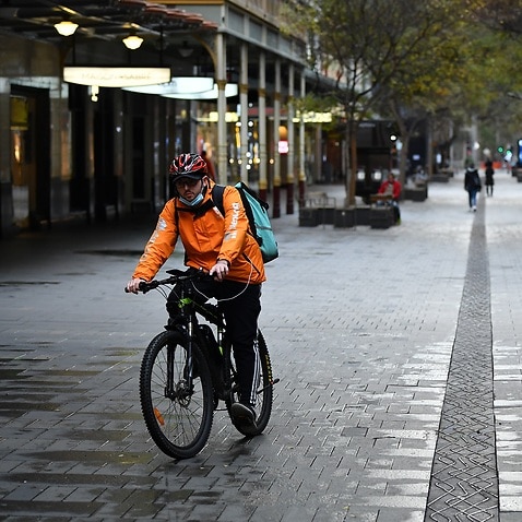 A food delivery worker wearing a face mask in the central business district in Sydney, Monday, June 28, 2021. 