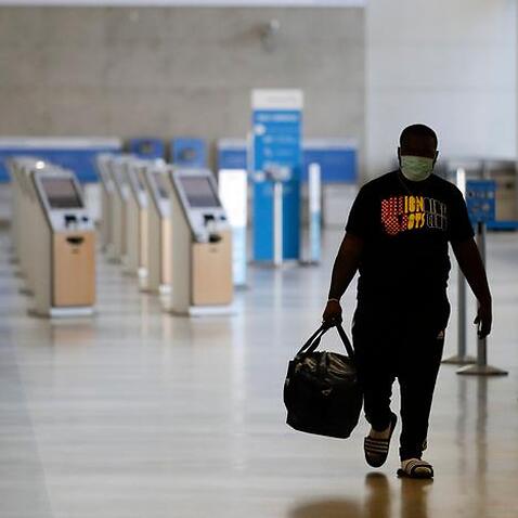 A traveler walks in a mostly empty American Airlines terminal at the Los Angeles International Airport in May, 2020.