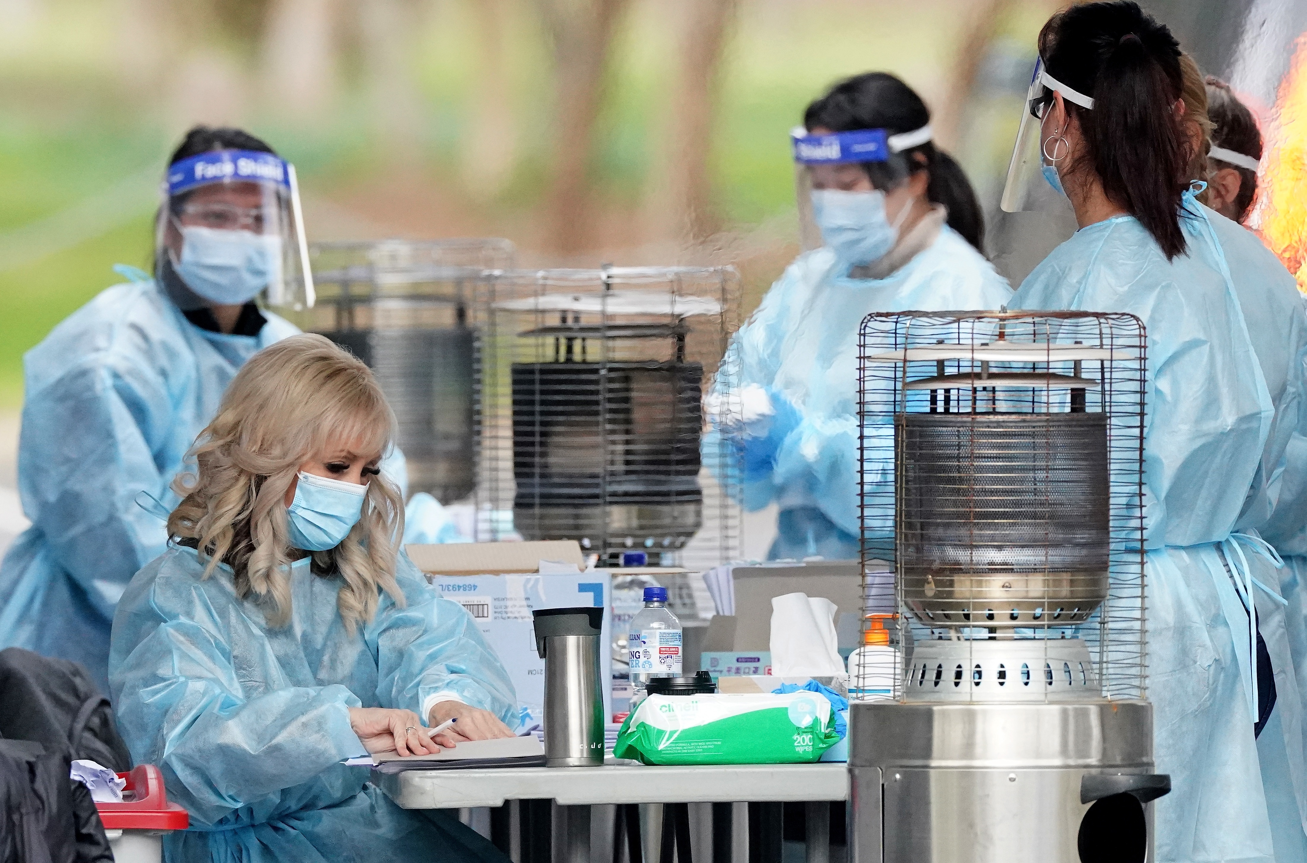 Medical workers look on before taking a sample from a person at a drive-through COVID-19 pop-up testing clinic at the Keilor Community Hub in Melbourne