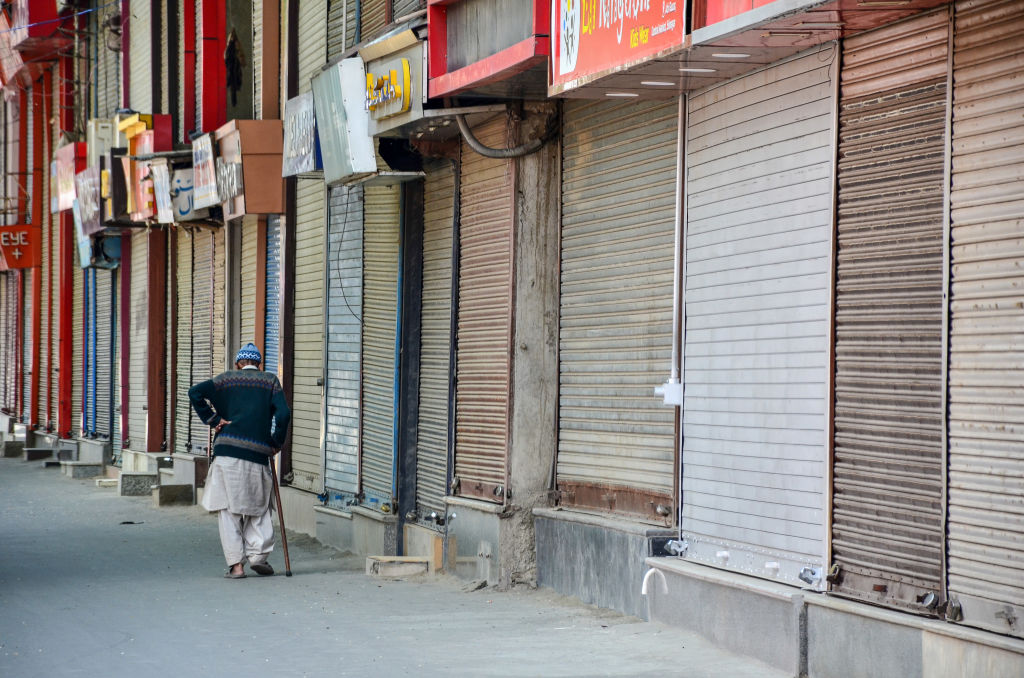 An elderly man walk past closed shops during a coronavirus curfew in Srinagar, Jammu and Kashmir.