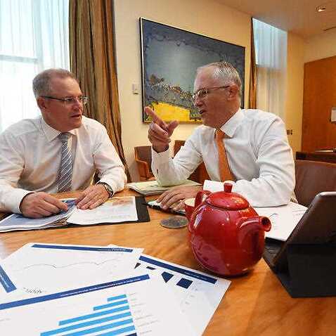 Treasurer Scott Morrison (L) and Prime Minister Malcolm Turnbull looking at the Budget Papers during a picture opportunity at Parliament House in Canberra