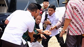 A handout photo made available by the Banten Police Headquarters shows a man (C) stabbing Indonesian Security Minister Wiranto 