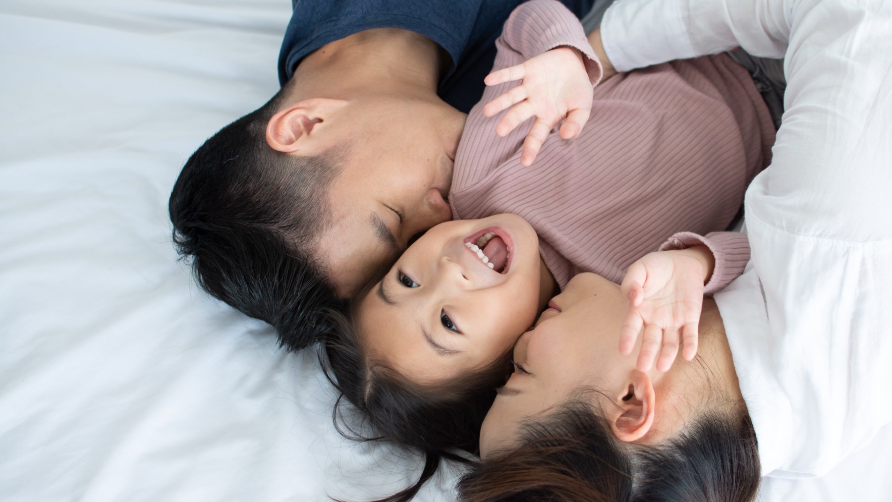 asian young family on the bed