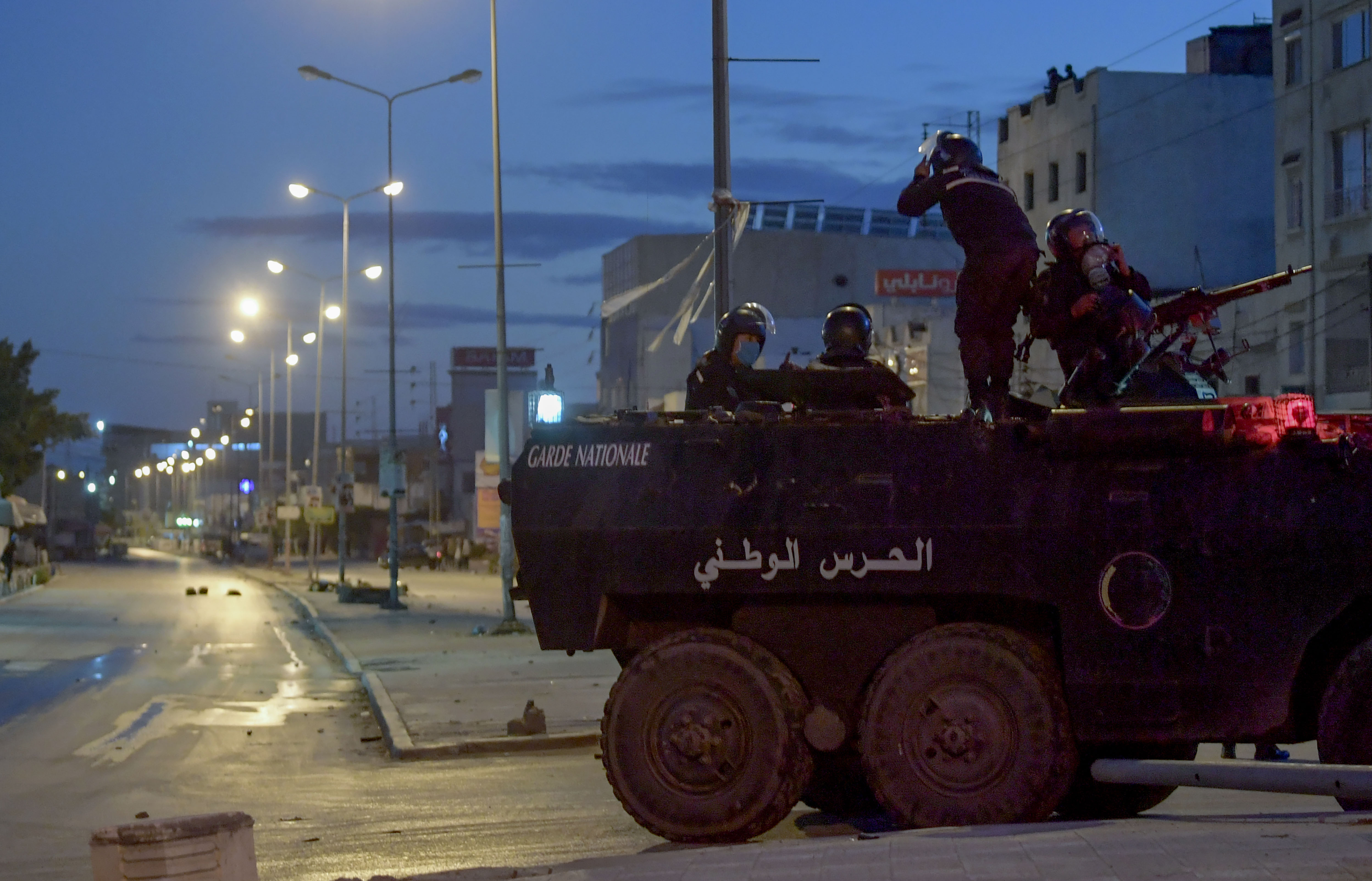 Members of the Tunisian National Guard sit atop an armoured vehicle amid clashes with demonstrators after a protest in Ettadhamen on 17 January.