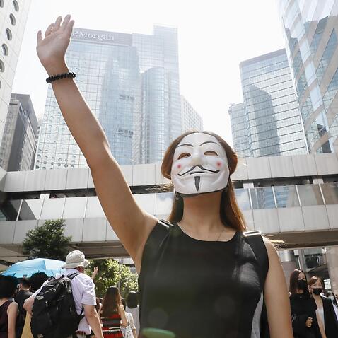 A woman takes part in a rally in Hong Kong on Oct. 4, 2019, in protest over the Hong Kong government's invoking of an emergency law to ban protesters from wearing face masks. (Kyodo via AP Images) ==Kyodo