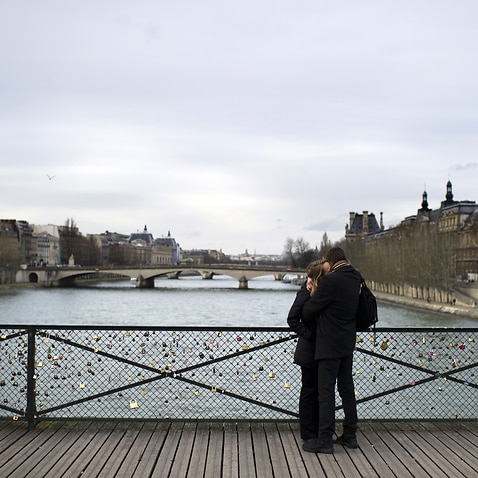 A couple kisses on the Pont des Arts, Paris