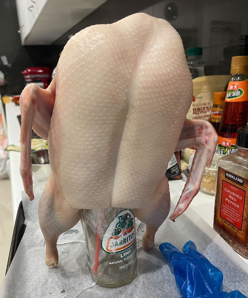 Duck ready for basting with glass bottle propping it up