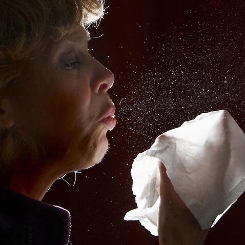 A woman sneezes