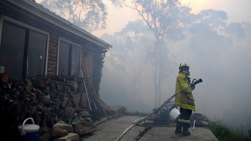 NSW Rural Fire Service and Fire and Rescue NSW personnel conduct property protection as a bushfire burns in Woodford NSW, Friday 8 November, 2019.