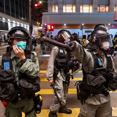 A police officer gestures with his baton in Hong Kong 