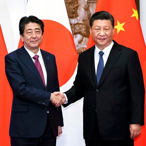 Japanese PM Shinzo Abe, left, shakes hands with Chinese President Xi Jinping during a rare visit. 