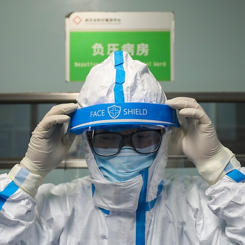 A doctor adjusts their protective outfit before entering the negative-pressure isolation ward in Jinyintan Hospital, Wuhan, China.