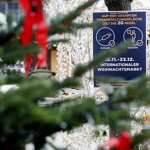 A sign indicating COVID-19 restrictions at the entrance of a Christmas market in Essen, Germany