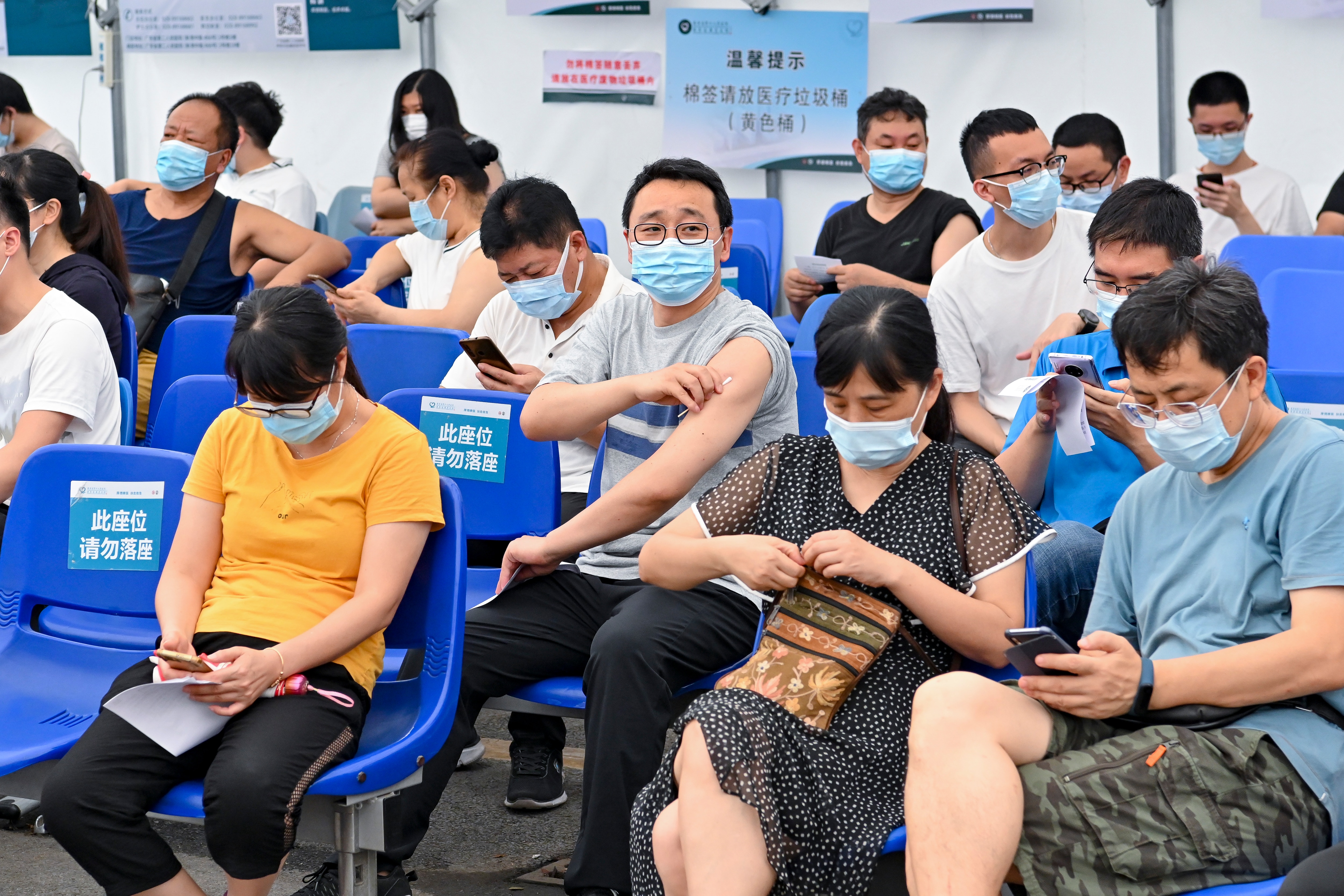 Local residents sit in an observation area after receiving a dose of the COVID-19 vaccine at Guangdong Second Provincial General Hospital.