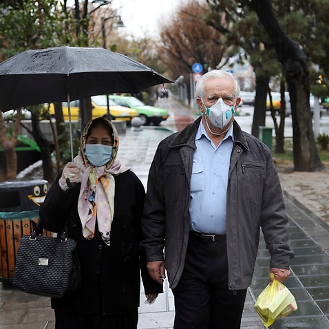 Pedestrians wear masks to help guard against the Coronavirus in downtown Tehran, Iran.