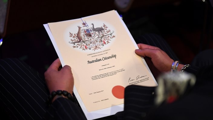 2017年1月26日星期四，澳大利亚公民身份的接收人在布里斯班澳大利亚日的公民身份仪式上持有证书。（AAP Image / Dan Peled）NO ARCHIVING
