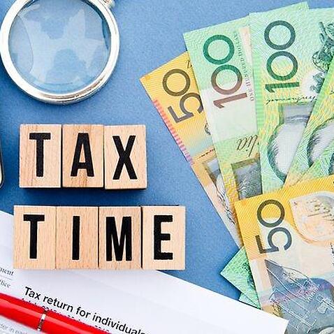 Tax Time - Australia - wooden letters with tax form, magnifying glass, money and calculator