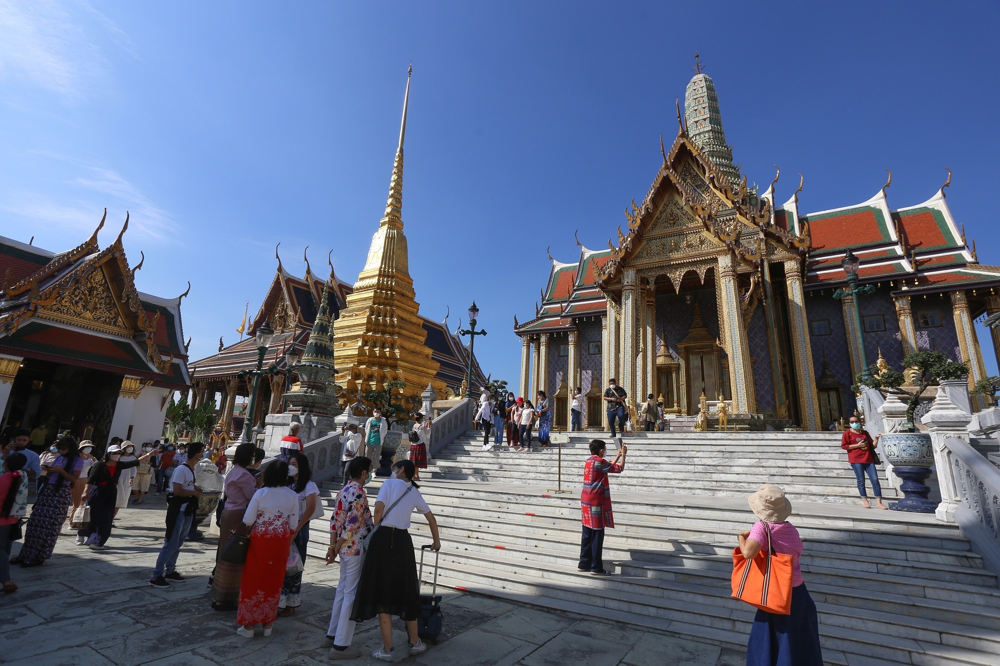 Tourists wearing facemasks as a preventive measure against the spread of coronavirus are seen at the Emerald Buddha Temple inside the Grand Palace in Bangkok. (Photo by Adisorn Chabsungnoen / SOPA Images/Sipa USA)