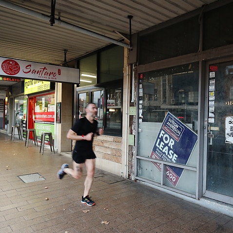 A runner passes a closed shop in Crows Nest in Sydney.