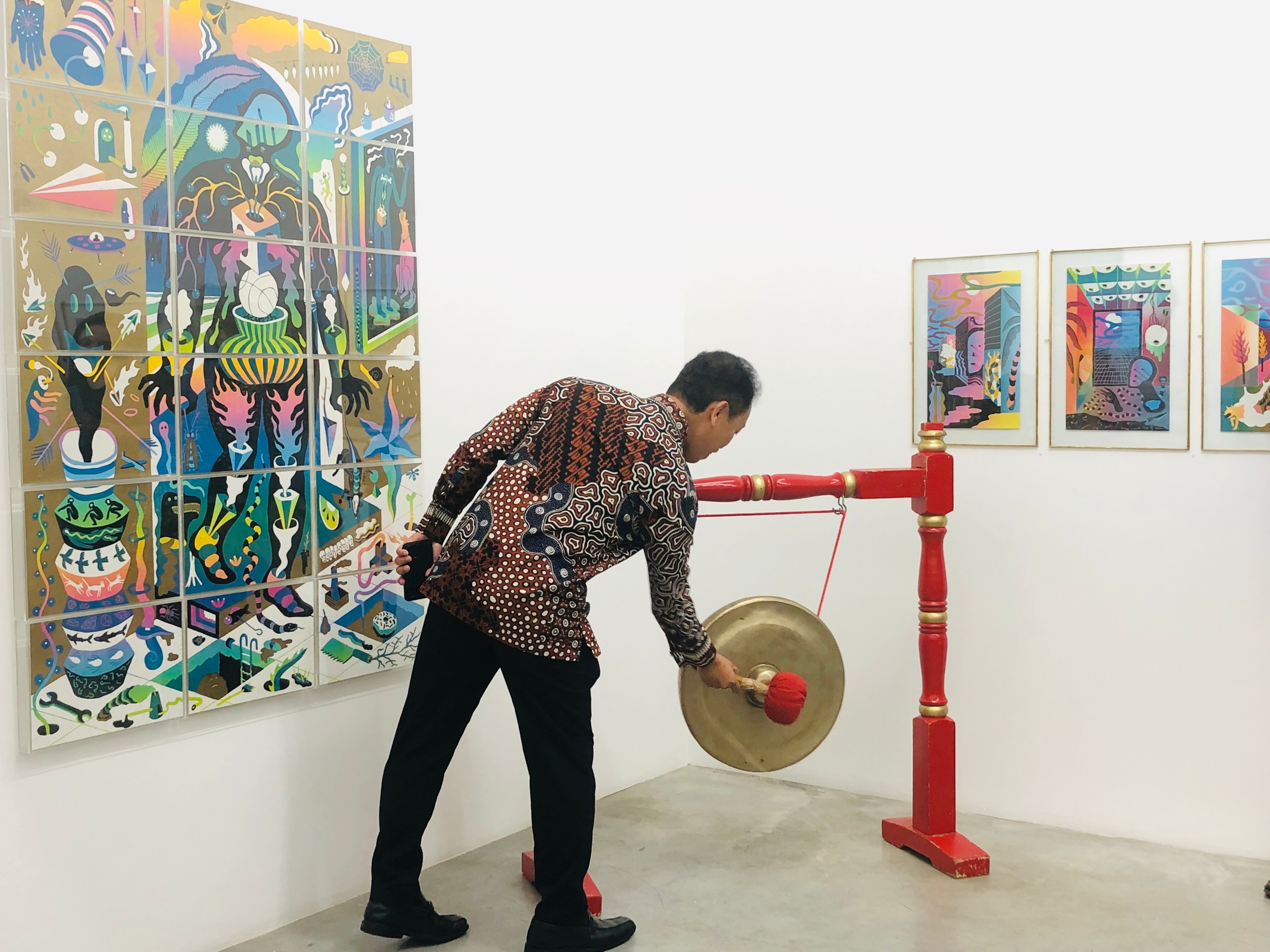 Indonesian Consul General Mr Heru Hartanto Subolo hits the gong as he opens 'Termasuk' art exhibition. 