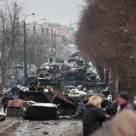 People look at the gutted remains of Russian military vehicles on a road in the town of Bucha, close to the capital Kyiv, Ukraine, Tuesday, March 1, 2022