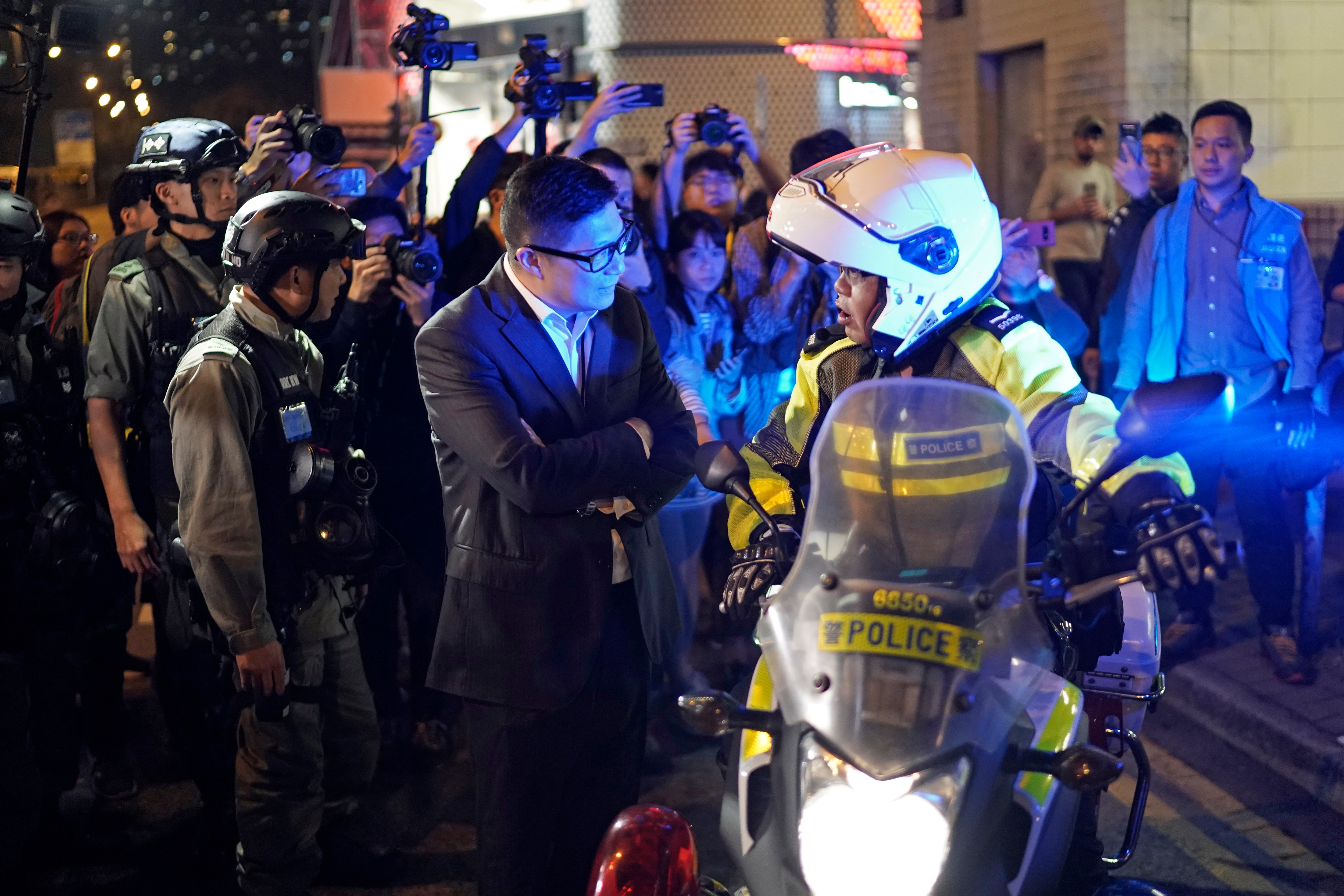 Police Commissioner Chris Tang Ping-keung, center, speaks to a police officer on duty during Christmas Eve in Hong Kong.